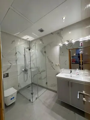 a bathroom with a glass shower and a sink at Square Appart in Marrakech