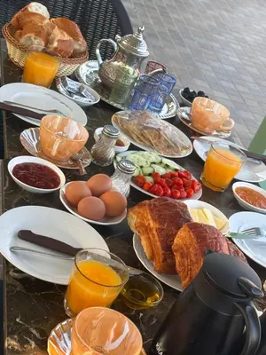 a table topped with plates of breakfast foods and orange juice at Square Appart in Marrakech