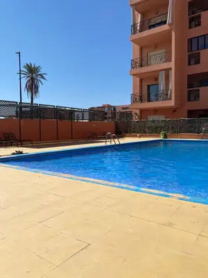 a large swimming pool in front of a building at Appartement cosy à deux pas du Jardin Majorelle in Marrakech