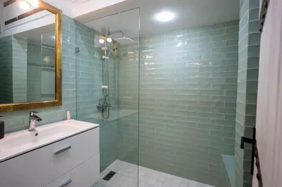 a bathroom with a sink and a glass shower at Élégant appartement avec terrasse au cœur Guéliz in Marrakech
