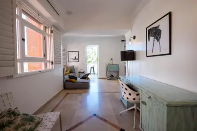a living room with white walls and a desk and a window at Élégant appartement avec terrasse au cœur Guéliz in Marrakech