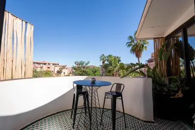 a blue table and two chairs on a balcony at Élégant appartement avec terrasse au cœur Guéliz in Marrakech