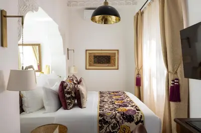 a bedroom with a white bed and a window at Riad Laz Mouassine & Wellness in Marrakech