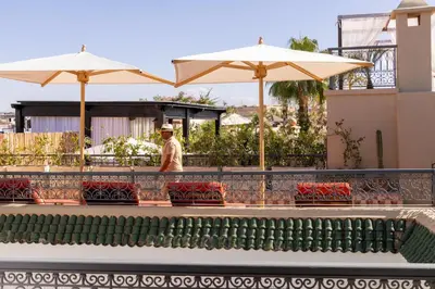 a man walking down a sidewalk with umbrellas at Riad Laz Mouassine & Wellness in Marrakech