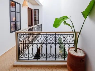 a plant in a vase next to a staircase at Riad Abati Piscine Privee avec Petit dejeuner et Terrasse in Marrakech