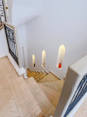 a staircase with white walls and two white candles at Riad Abati Piscine Privee avec Petit dejeuner et Terrasse in Marrakech