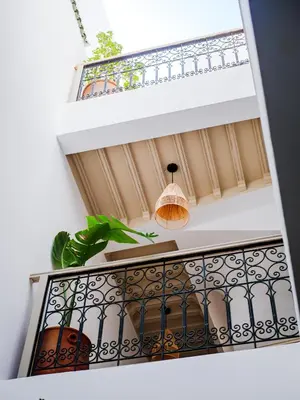 a balcony with a potted plant and a pendant light at Riad Abati Piscine Privee avec Petit dejeuner et Terrasse in Marrakech