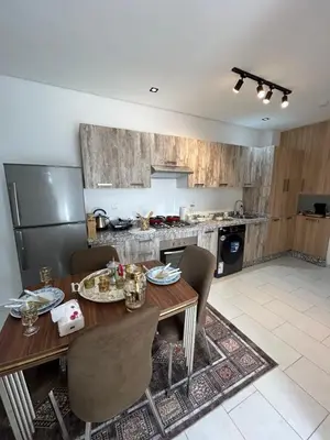 a kitchen with a wooden table and chairs in a room at JASMINe in Marrakech