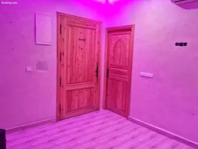 an empty room with a wooden door and purple lights at Hostel GSK in Marrakech