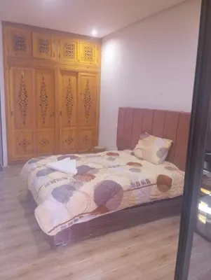 a bedroom with a bed and wooden cabinets at Hostel GSK in Marrakech