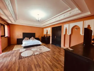 a large room with a bed with two cats laying on it at Naoura House in Marrakech