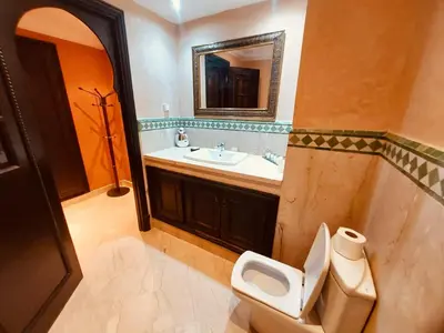 a bathroom with a sink and a toilet and a mirror at Naoura House in Marrakech