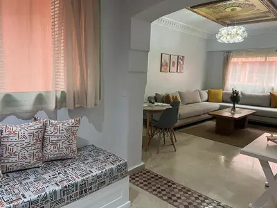 a living room with a couch and a table at Bel Appartement meublé avec Piscine, l'hivernage à Marrakech in Marrakech