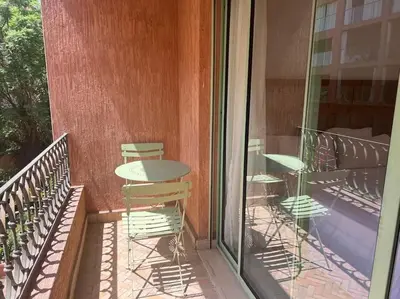 a patio with a table and chairs on a balcony at Bel Appartement meublé avec Piscine, l'hivernage à Marrakech in Marrakech