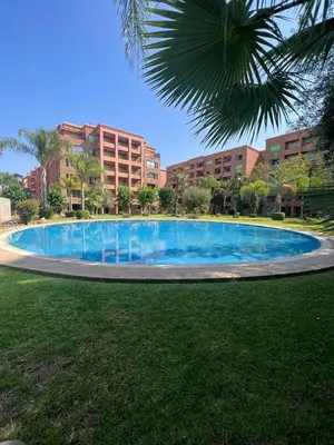 a large blue swimming pool in front of a building at Bel Appartement meublé avec Piscine, l'hivernage à Marrakech in Marrakech