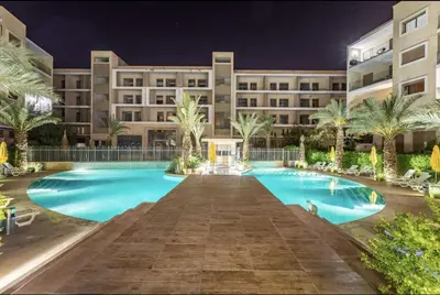 a hotel with a large swimming pool at night at Pearl Garden Studio Cosy Lux Elegant Sunny Terrace Piscine in Marrakech