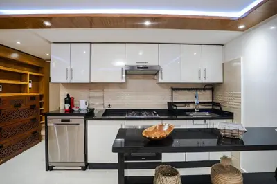 a kitchen with white cabinets and a black counter top at Appartement cosy au cœur de Semlalia in Marrakech