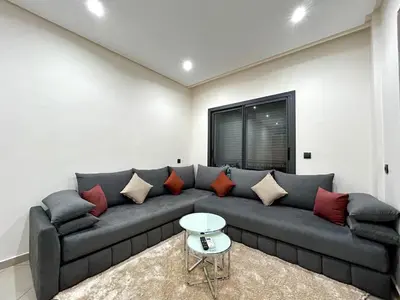 a living room with a gray couch with pillows at Appartement a Gueliz in Marrakech