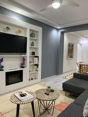 a living room with a couch and a tv at Luxury Apartment in City Center of Marrakech in Marrakech