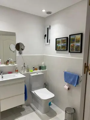 a white bathroom with a toilet and a sink at Luxury Apartment in City Center of Marrakech in Marrakech
