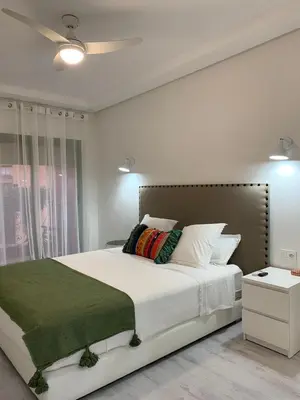 a bedroom with a large bed with a green blanket at Luxury Apartment in City Center of Marrakech in Marrakech