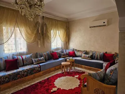 a living room with a blue couch and a red rug at Appt 10min pied jardin Majorelle in Marrakech