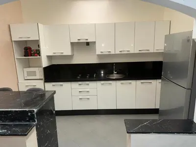 a kitchen with white cabinets and a stainless steel refrigerator at Appt 10min pied jardin Majorelle in Marrakech