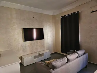 a living room with a couch and a flat screen tv at Appt 10min pied jardin Majorelle in Marrakech