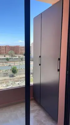 a large metal door in a room with a window at Luxury and Healthy designed Apartment with pool in Marrakech