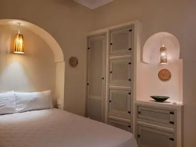 a bedroom with a bed and a cabinet and a door at Dar Amazigh mit 3 Schlafzimmern in Marrakech