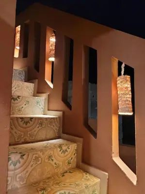 a bedroom with two beds and two lights on the wall at Dar Amazigh mit 3 Schlafzimmern in Marrakech
