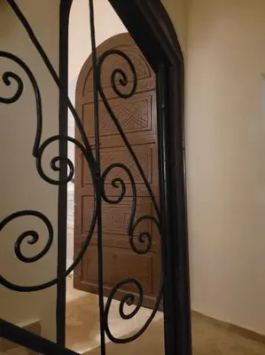 a wooden door is seen through a iron gate at Dar Amazigh mit 3 Schlafzimmern in Marrakech
