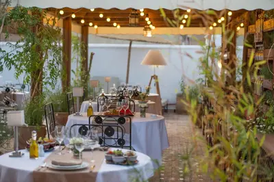 a table set up for a dinner party in a greenhouse at Hotel & Spa Riad El Walaa in Marrakech