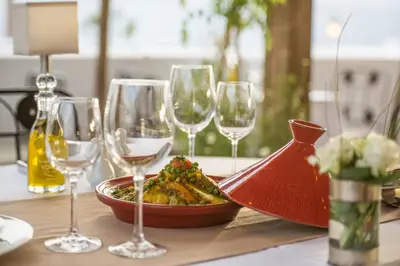 a table with a plate of food and wine glasses at Hotel & Spa Riad El Walaa in Marrakech