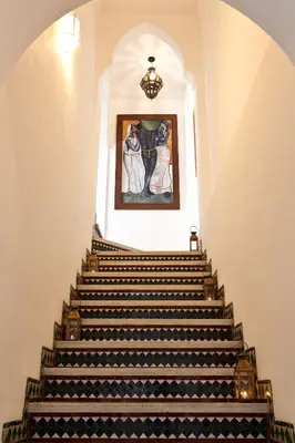 a staircase in a building with a painting on the wall at Hotel & Spa Riad El Walaa in Marrakech