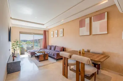 a living room with a table and a couch at Cute And Modern Appart In Prestigia in Marrakech