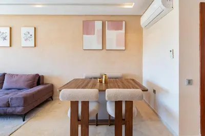 a living room with a wooden table and a couch at Cute And Modern Appart In Prestigia in Marrakech