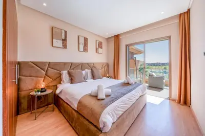 a bedroom with a large bed with a large window at Cute And Modern Appart In Prestigia in Marrakech