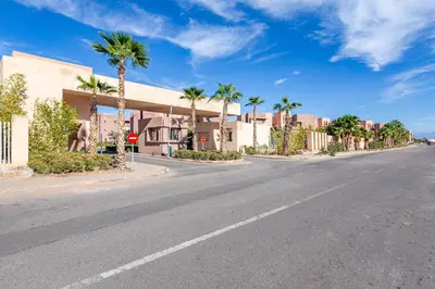 an empty street with palm trees and a building at 2Bedrooms In Prestigia - Very Well Equipped With View in Marrakech