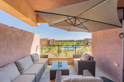 a living room with a couch and an umbrella at 2Bedrooms In Prestigia - Very Well Equipped With View in Marrakech