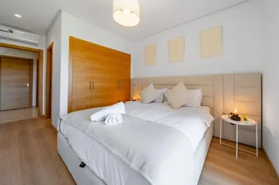 a bedroom with a large white bed with a wooden headboard at 2Bedrooms In Prestigia - Very Well Equipped With View in Marrakech