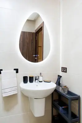 a bathroom with a white sink and a mirror at Appartement Piscine & Parking in Marrakech