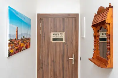 a wooden door with a sign on it next to a picture at Appartement Piscine & Parking in Marrakech