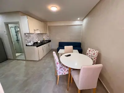 a small kitchen with a white table and chairs at Résidence Miramas 2 - C5 in Marrakech