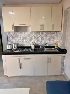 a kitchen with white cabinets and a sink at Résidence Miramas 2 - C5 in Marrakech