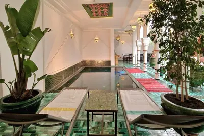 a room with a pool with two chairs and plants at Riad LakLak Nouvelle 400m2 mit Pool in der Medina in Marrakech