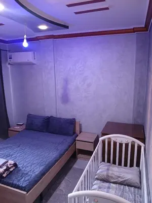 a small bedroom with a bed and a table at AC Family apartment steps away from everything in Marrakech