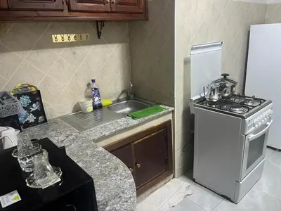 a kitchen with a stove and a sink and a refrigerator at AC Family apartment steps away from everything in Marrakech