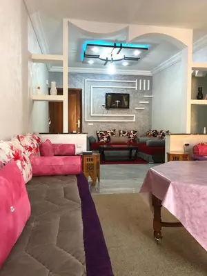 a living room with a pink couch and a table at AC Family apartment steps away from everything in Marrakech