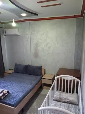 a small bedroom with a bed and a table at AC Family apartment steps away from everything in Marrakech